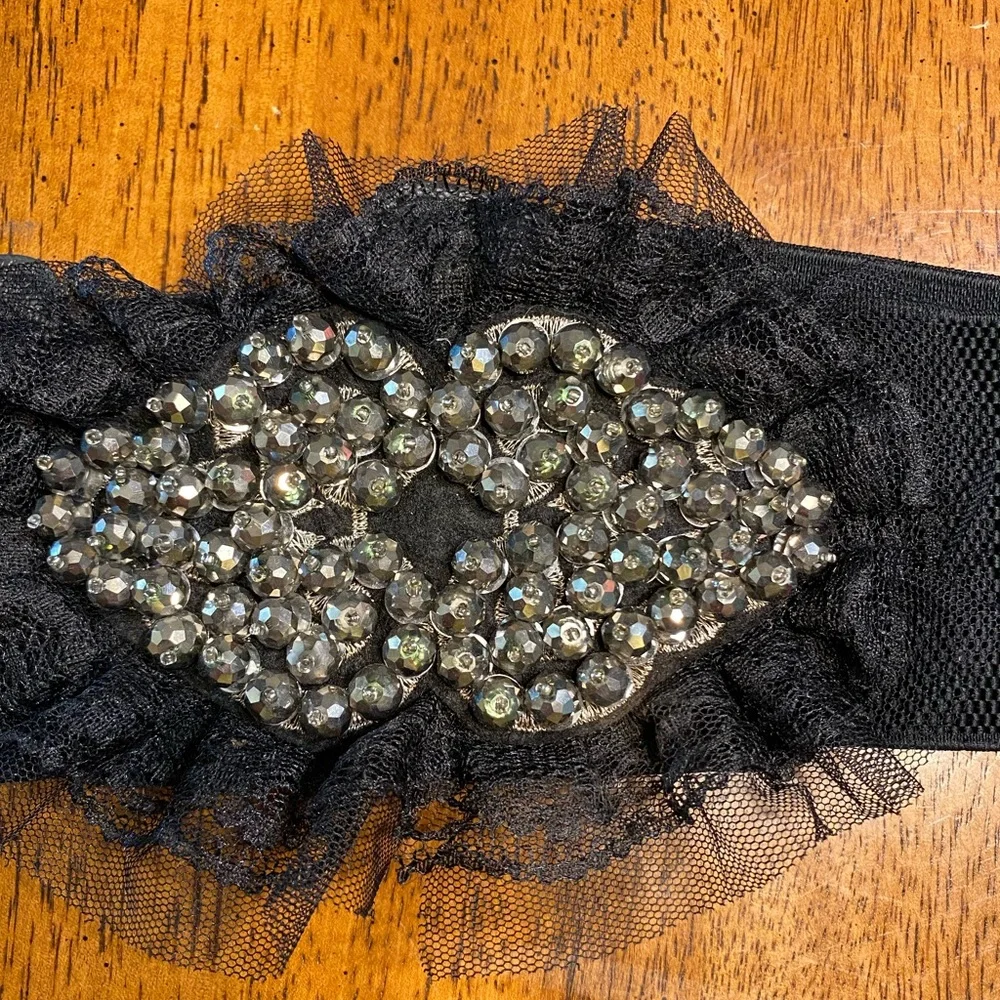 black belt with lace and sequins. Stretchy Size S/M. Snap closure.